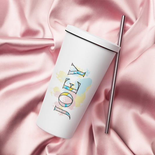 white tumbler laying on pink cloth. Tumbler says Joey in colorful lettering with pink, yellow, and blue paws in the background of JOEY